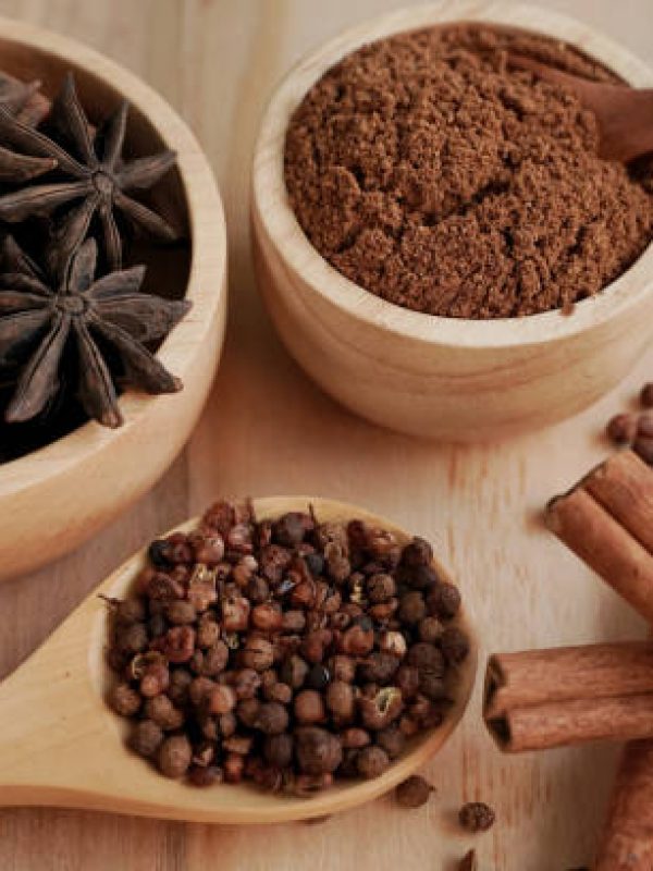 Stew powder and spices in a wooden cup with black background, industry concept